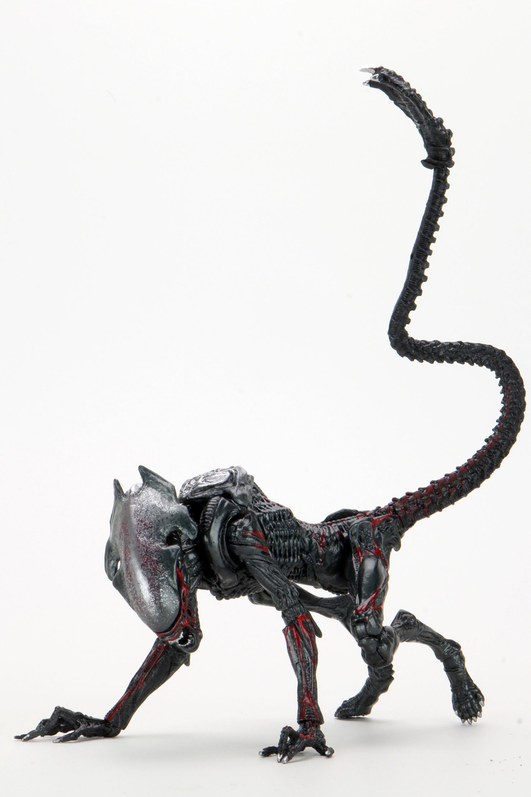 Action figure of a creature with a long tail on a white background