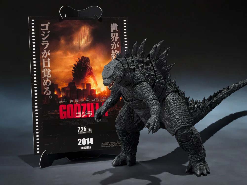  Godzilla figure in front of a movie poster for 'Godzilla' 2014