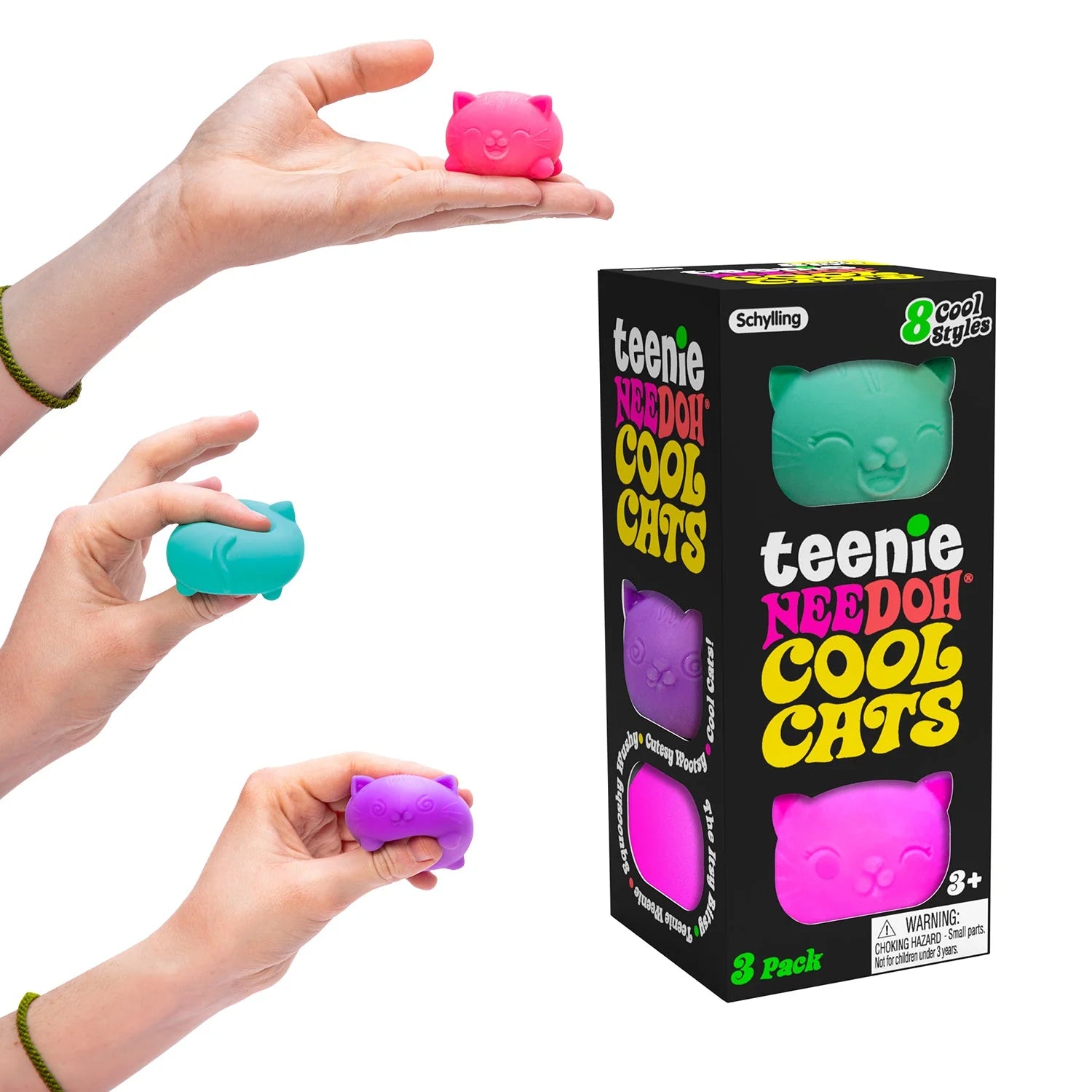 Hands holding pink, blue, and purple 'teenie NEEDOH COOL CATS' toys with their packaging on a white background. Schylling - Cool Cats Teenie Nee Doh.