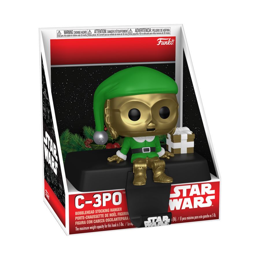 Funko Branded packaging with C-3PO sitting on a bench with a gold Christmas present. At the bottom of the bench is a hook for Christmas stockings. 